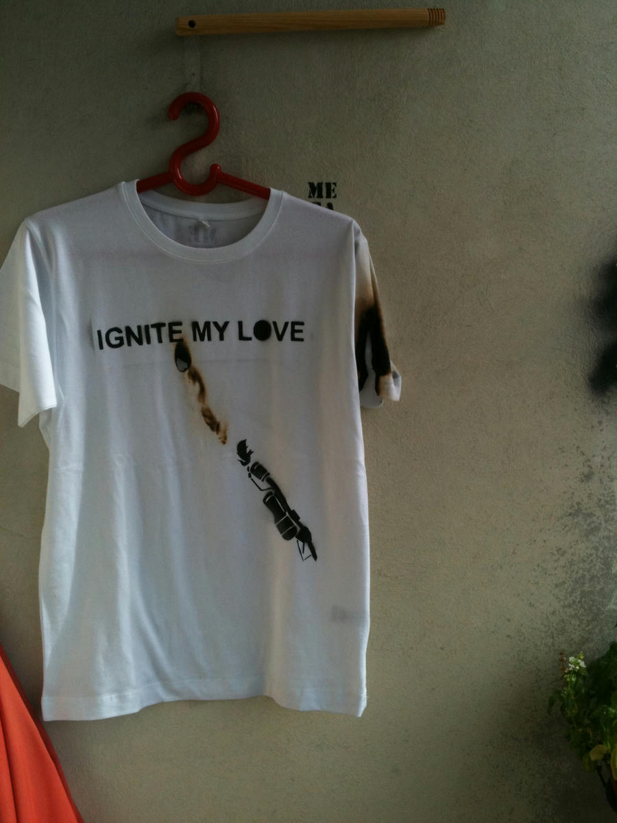 A t-shirt with burn marks featuring a flamethrower and the caption: IGNITE MY LOVE.