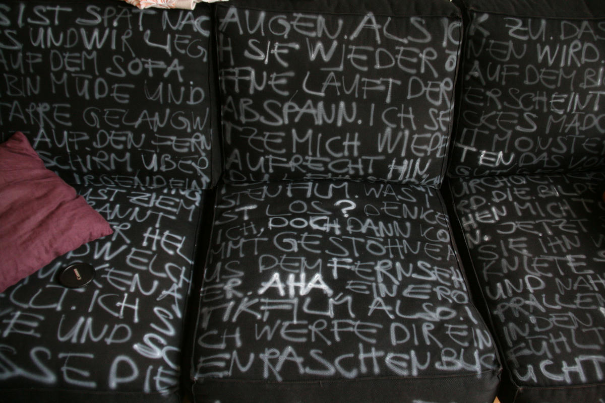 A black sofa with white airbrushed text.