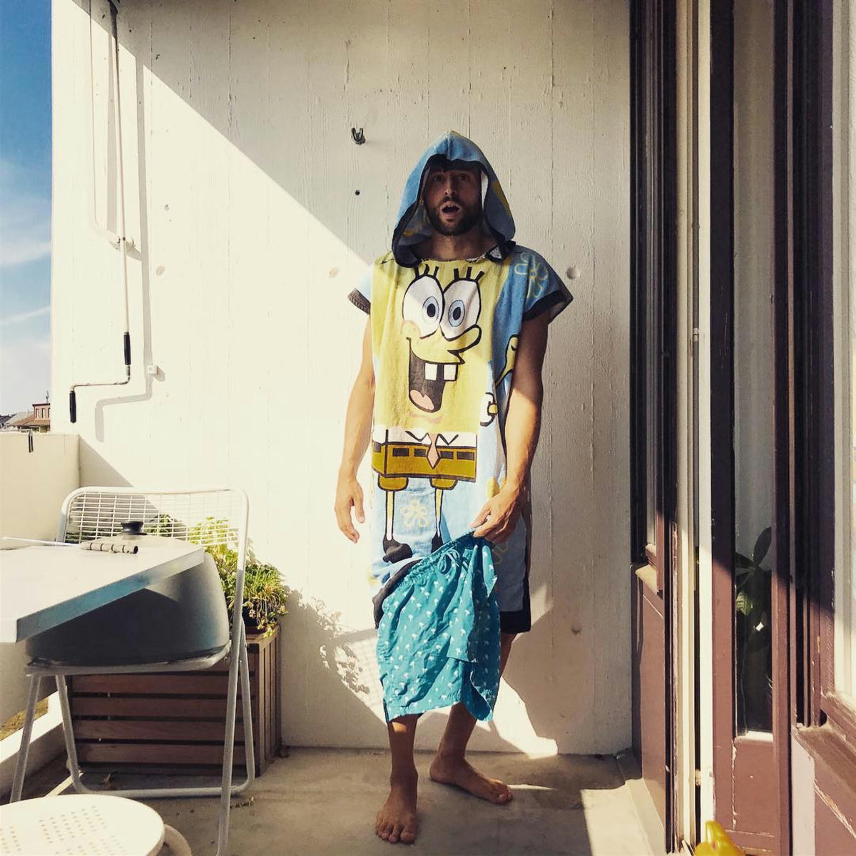 Surprised looking man wearing a surf poncho